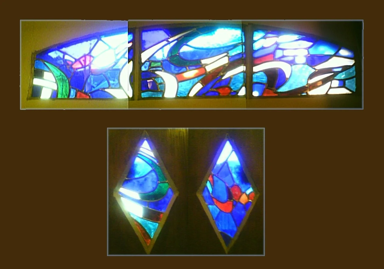 Une imposte et deux panneaux en verre, avec des courbes et des couleurs dominantes bleues.